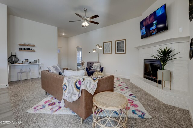 1814 Fountain Rd, Webb City, MO 64870 - living area with ceiling fan, arched walkways, a fireplace, baseboards, and carpet flooring