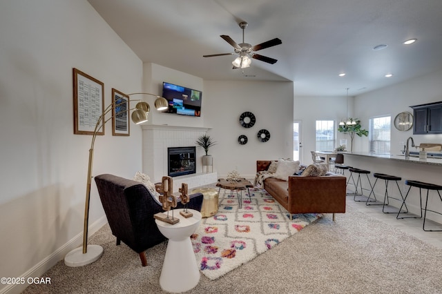 living area with a ceiling fan, light colored carpet, a brick fireplace, baseboards, and recessed lighting