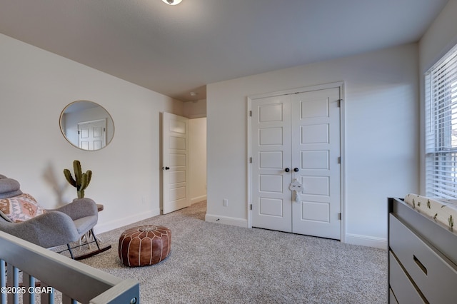 carpeted bedroom featuring baseboards and a closet