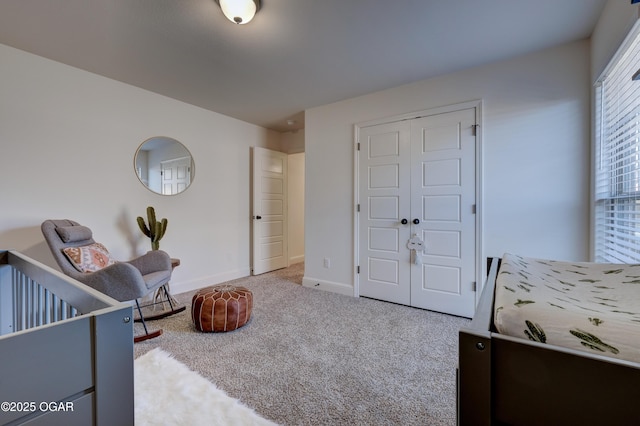 carpeted bedroom with baseboards and a closet