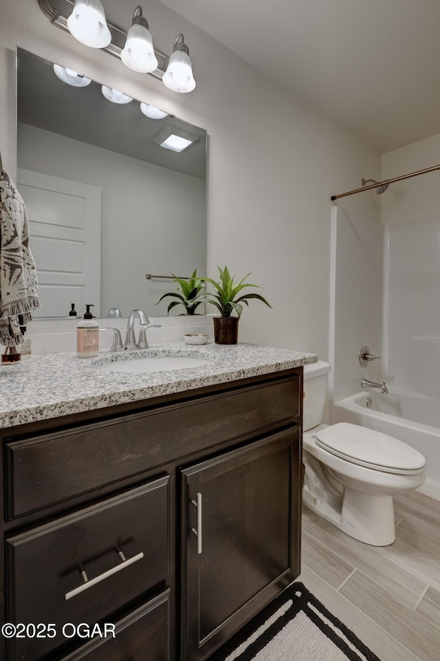 full bath featuring vanity, toilet, and  shower combination