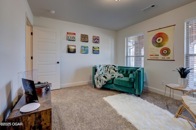 sitting room with carpet floors, baseboards, visible vents, and a healthy amount of sunlight