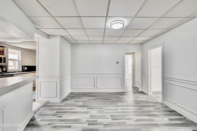530 N Joplin Ave, Joplin, MO 64801 - interior space with wainscoting, a decorative wall, a drop ceiling, and light wood finished floors