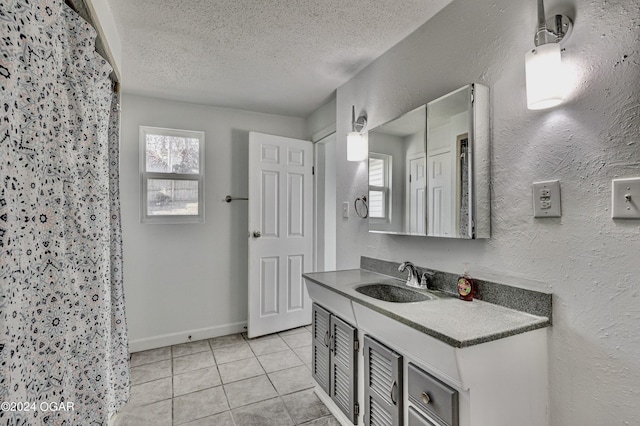 530 N Joplin Ave, Joplin, MO 64801 - bathroom with walk in shower, tile patterned flooring, vanity, a textured ceiling, and baseboards