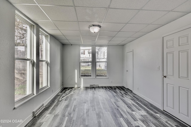 530 N Joplin Ave, Joplin, MO 64801 - unfurnished room with visible vents, a paneled ceiling, wood finished floors, and a healthy amount of sunlight