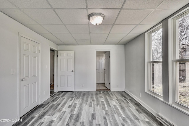 530 N Joplin Ave, Joplin, MO 64801 - unfurnished bedroom with light wood-type flooring, a paneled ceiling, visible vents, and multiple windows