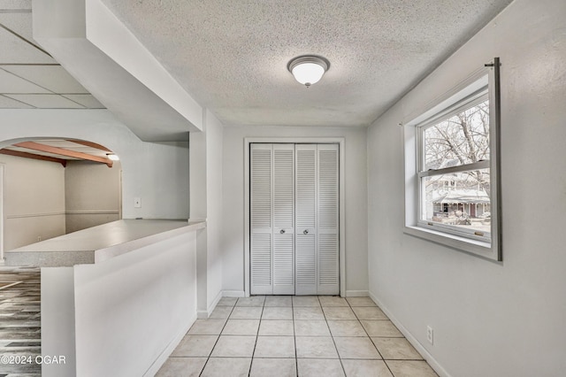 530 N Joplin Ave, Joplin, MO 64801 - foyer with arched walkways, a textured ceiling, light tile patterned floors, and baseboards