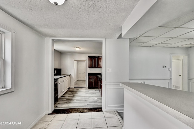 530 N Joplin Ave, Joplin, MO 64801 - kitchen featuring light countertops, light tile patterned flooring, dark brown cabinetry, and a textured ceiling