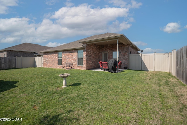 back of house featuring brick siding, a patio, and a gate