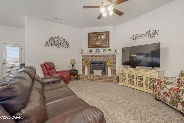 carpeted living area featuring ceiling fan and a brick fireplace