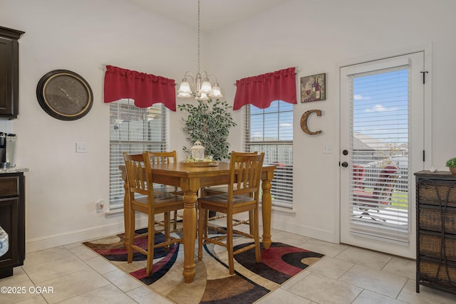dining area featuring light tile patterned floors, baseboards, a chandelier, and lofted ceiling
