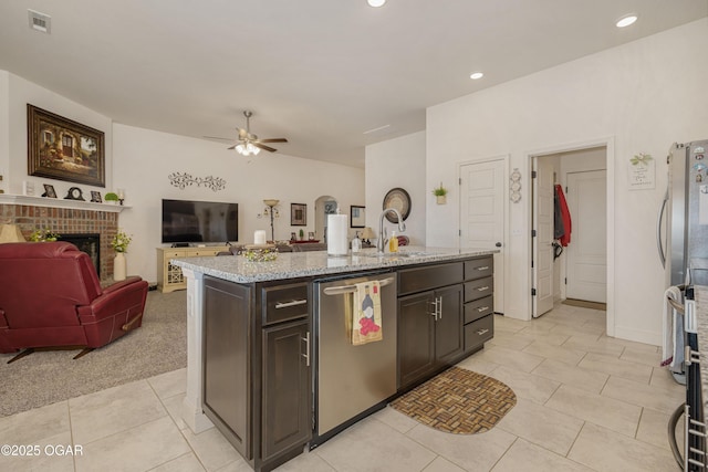 kitchen featuring appliances with stainless steel finishes, a sink, a ceiling fan, open floor plan, and light tile patterned floors