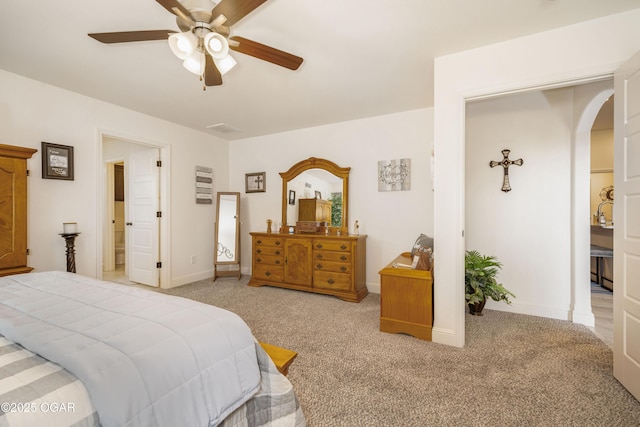 bedroom with arched walkways, light carpet, baseboards, and ceiling fan