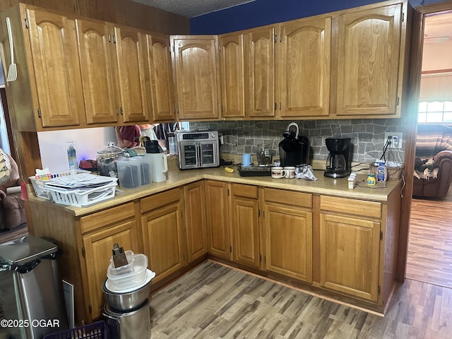 1793 8000th Rd, Oswego, KS 67356 - kitchen with light countertops, brown cabinets, decorative backsplash, and light wood-style flooring