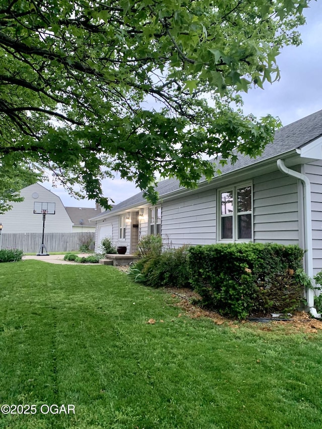 view of yard featuring fence and an attached garage