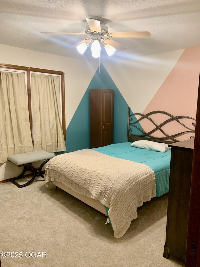 bedroom featuring carpet flooring, a ceiling fan, and a textured ceiling