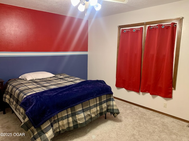 carpeted bedroom featuring baseboards, a textured ceiling, and ceiling fan