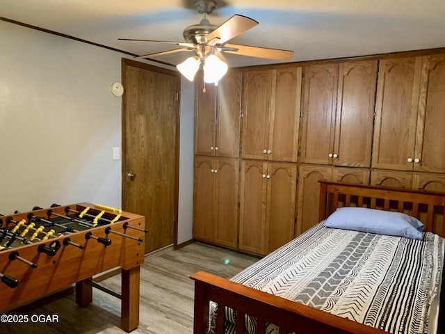 bedroom featuring light wood-type flooring, baseboards, and ceiling fan