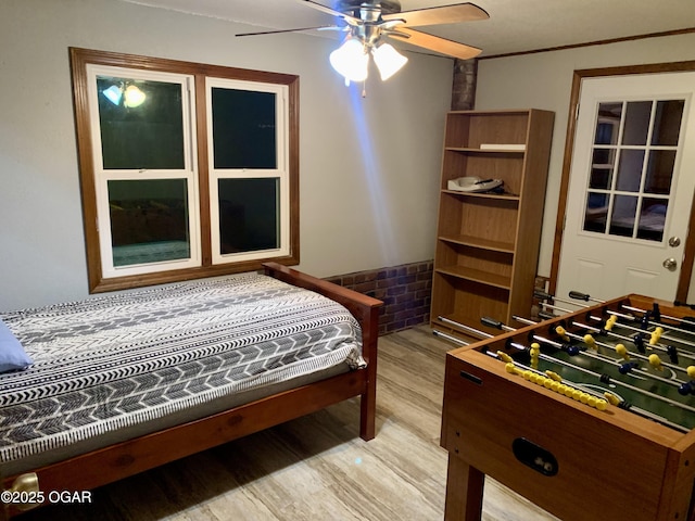 bedroom with wainscoting and light wood-type flooring