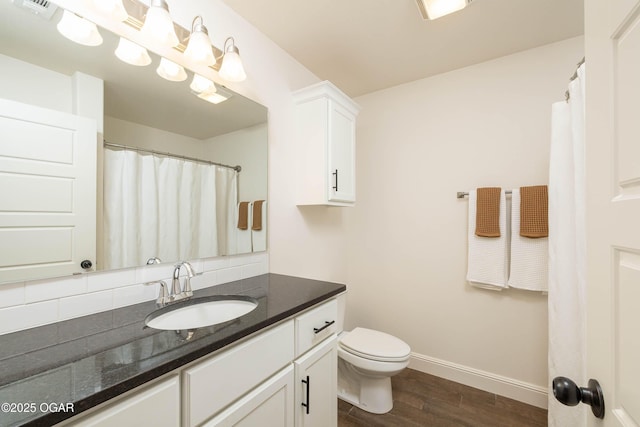 2006 Eagle Dr, Neosho, MO 64850 - full bathroom featuring wood finished floors, baseboards, vanity, toilet, and backsplash