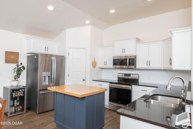 2006 Eagle Dr, Neosho, MO 64850 - kitchen featuring appliances with stainless steel finishes, a sink, wooden counters, white cabinets, and vaulted ceiling