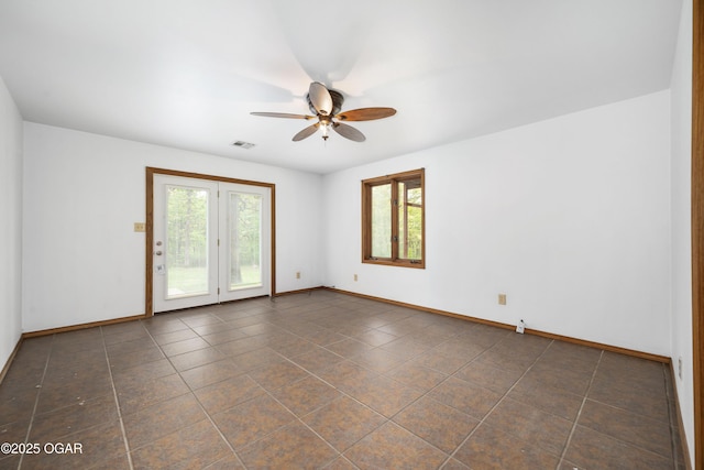spare room featuring baseboards, visible vents, a ceiling fan, and a wealth of natural light
