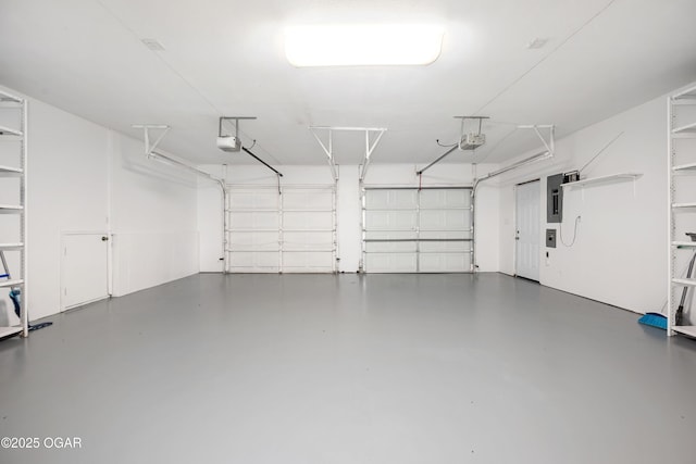 garage with a garage door opener and electric panel