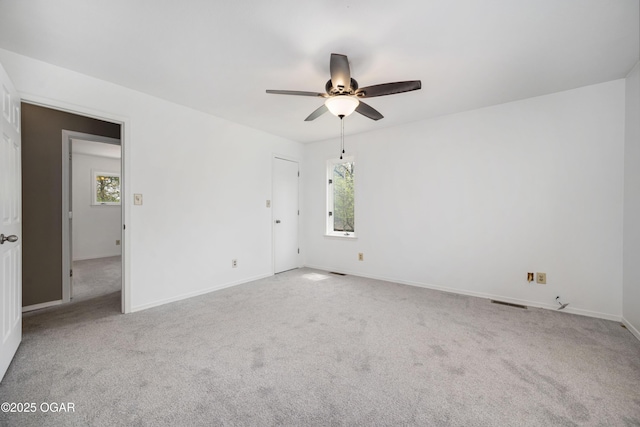 empty room featuring carpet floors, ceiling fan, and baseboards