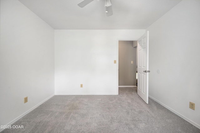 carpeted spare room with baseboards and ceiling fan