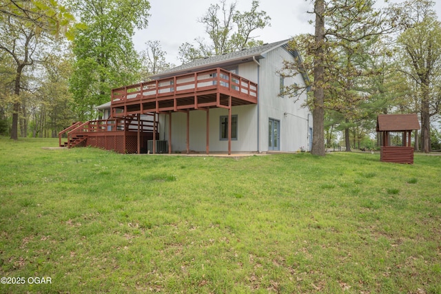 rear view of house featuring a wooden deck, a yard, and cooling unit