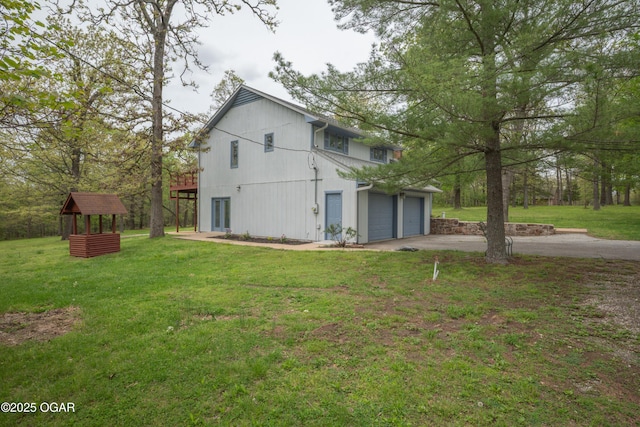 view of side of property featuring a garage, a yard, and driveway