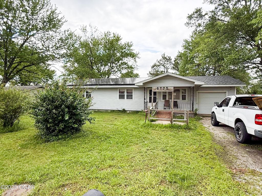 6775 SE Kiwi Ln, Riverton, KS 66770 - ranch-style home featuring an attached garage, a front lawn, driveway, and a porch