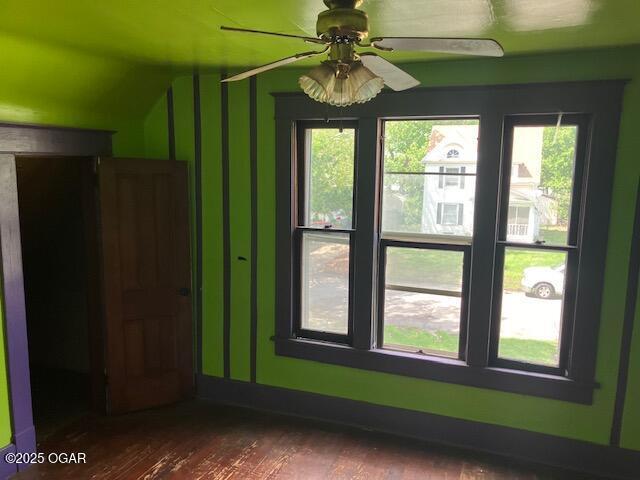 interior space featuring plenty of natural light, a ceiling fan, and dark wood finished floors