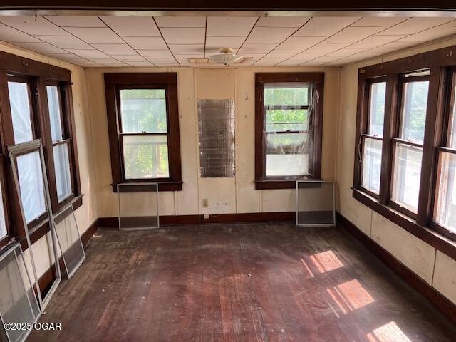 unfurnished room with baseboards and dark wood-style flooring