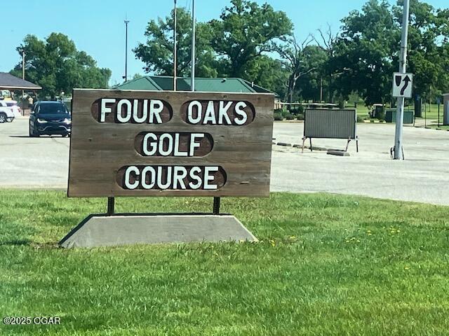 community / neighborhood sign featuring a yard