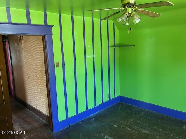 unfurnished room featuring baseboards, ceiling fan, and wood finished floors