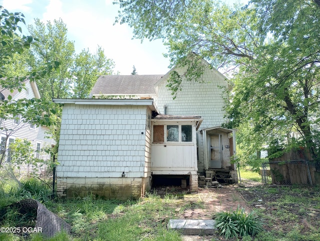 back of property featuring roof with shingles and fence