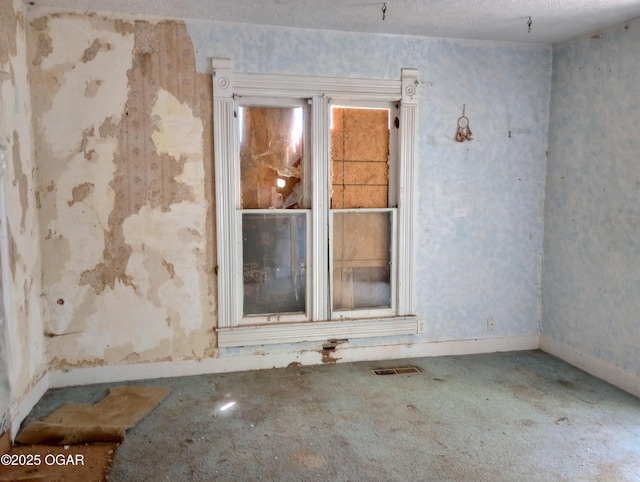carpeted spare room with visible vents and baseboards