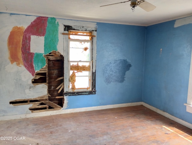 unfurnished room featuring crown molding, baseboards, ceiling fan, and wood finished floors