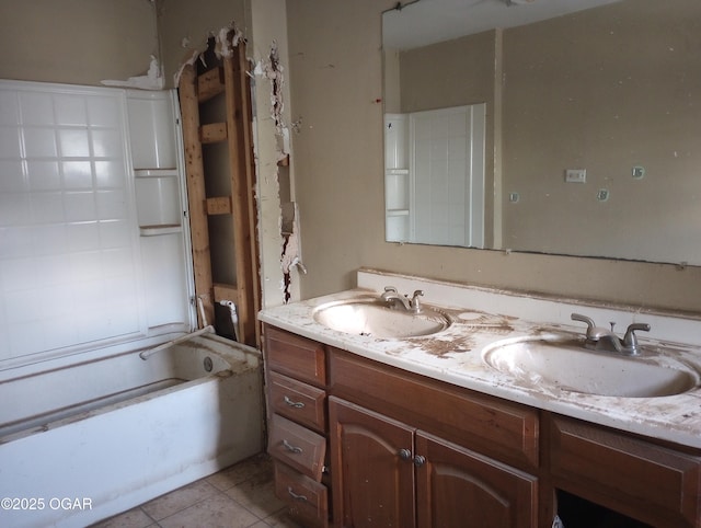 full bathroom with a sink, double vanity, a washtub, and tile patterned floors