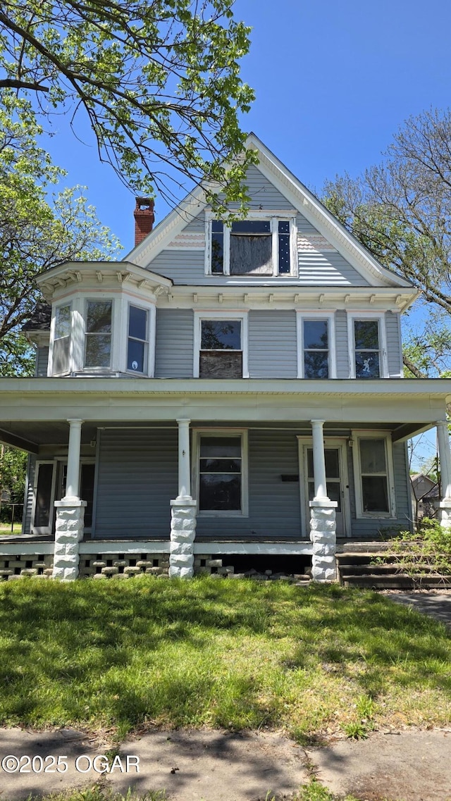 114 S Pennsylvania St, Webb City, MO 64870 - view of front facade with a chimney, a front lawn, and covered porch