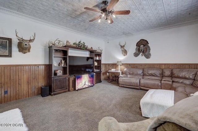 1418 Cleveland Ave, Baxter Springs, KS 66713 - carpeted living room featuring a wainscoted wall, a ceiling fan, wooden walls, an ornate ceiling, and crown molding