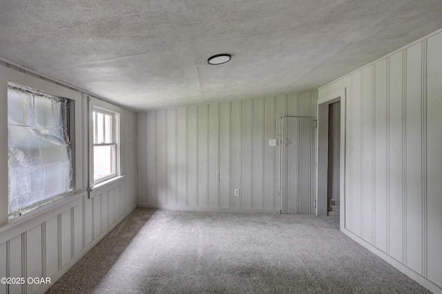 unfurnished room featuring a textured ceiling and carpet flooring