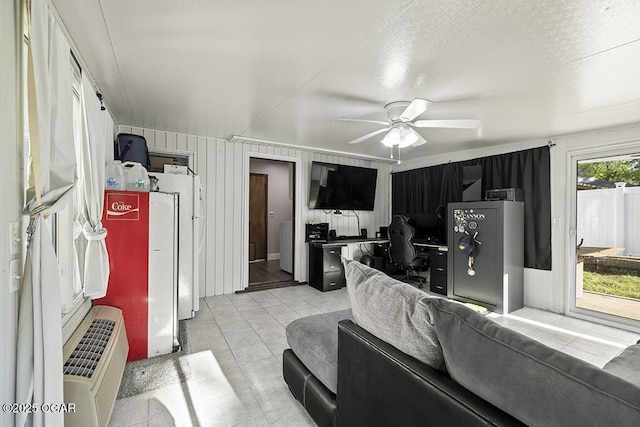 living area featuring light tile patterned floors and a ceiling fan