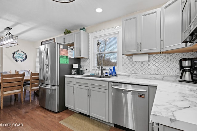 400 Silverwood Ln, Joplin, MO 64801 - kitchen featuring stainless steel appliances, a sink, backsplash, dark wood-style floors, and light stone countertops