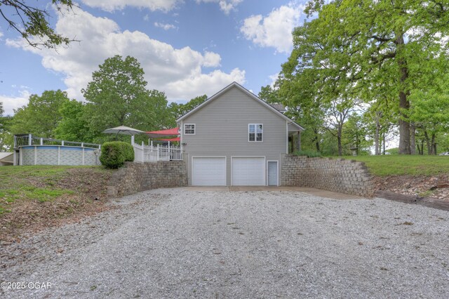4537 Dolphin Dr, Joplin, MO 64804 - view of side of home with driveway, a garage, and an outdoor pool