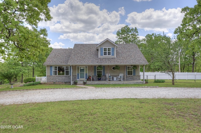 4537 Dolphin Dr, Joplin, MO 64804 - view of front of house with covered porch, roof with shingles, fence, stone siding, and a front lawn