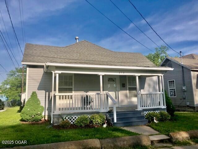 212 N Jefferson St, Webb City, MO 64870 - bungalow-style house with a front yard, a porch, and a shingled roof