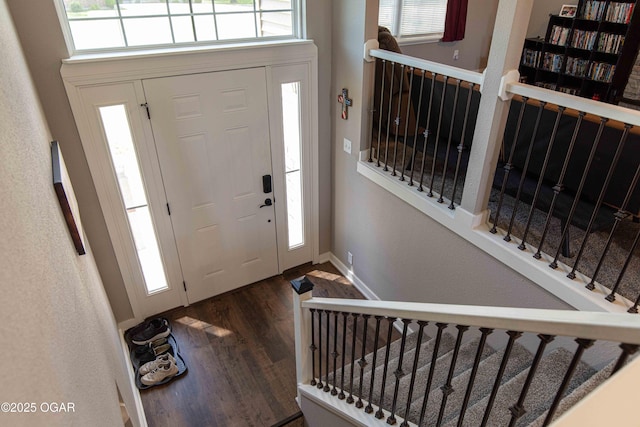 entrance foyer with stairs, baseboards, and wood finished floors