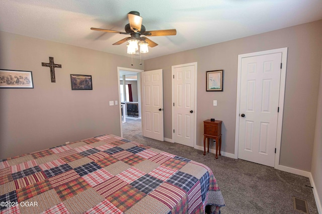 carpeted bedroom featuring baseboards, a ceiling fan, and visible vents